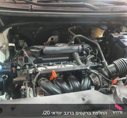 מנוע רכב עם צינורות, כבלים ומיכל נוזל כחול